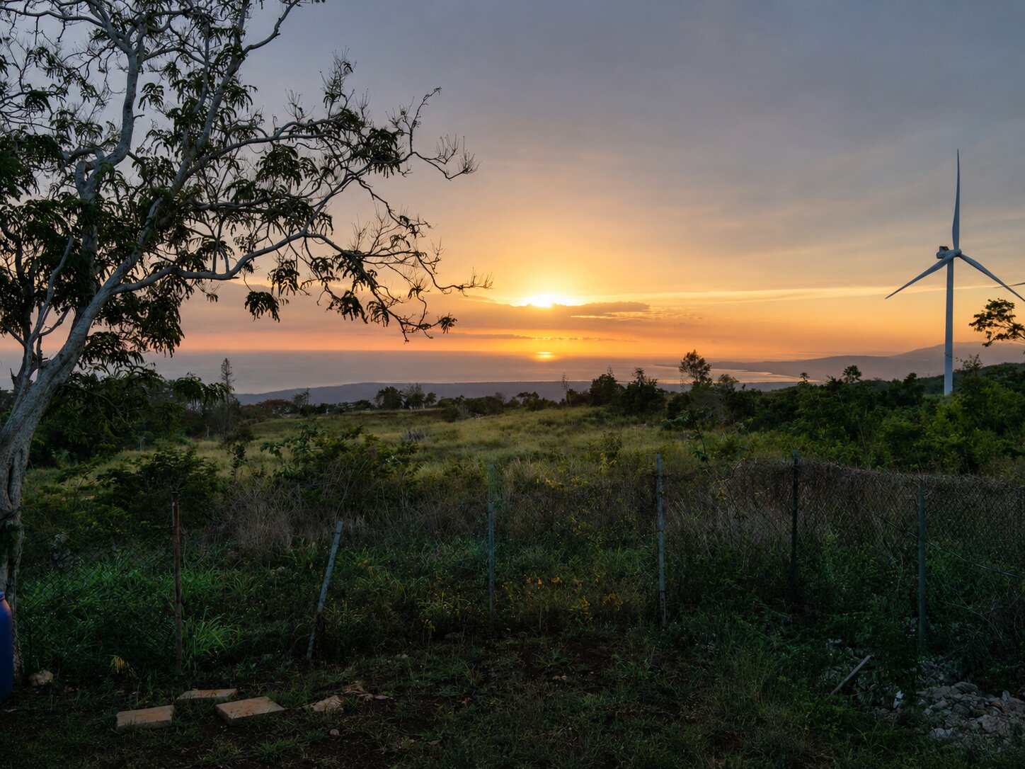 Golden-hour sunset over the sea, seen from the villa grounds